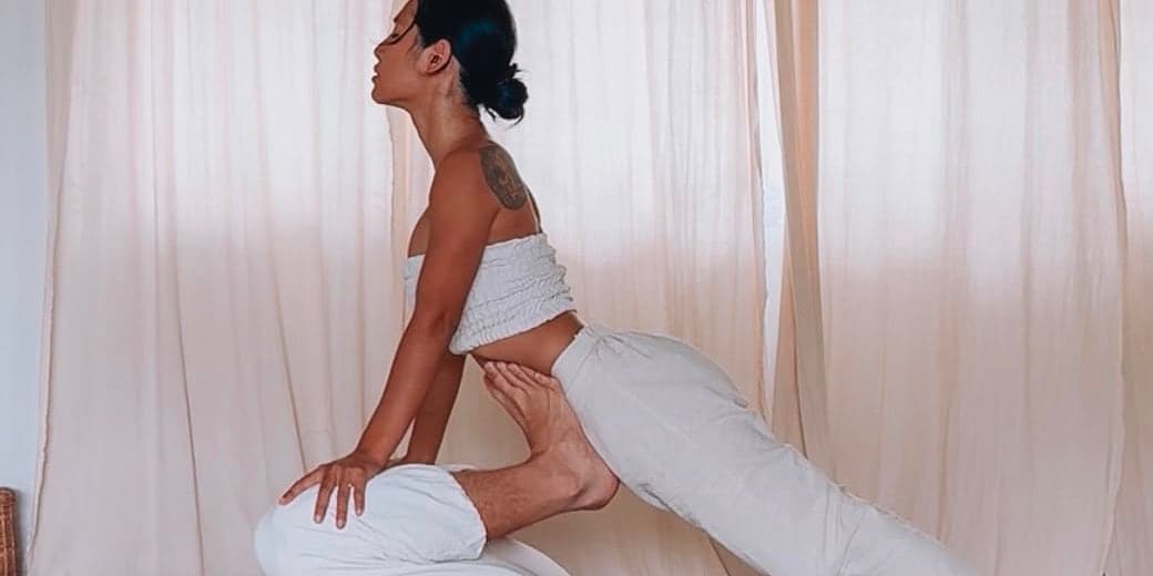 ครูณิชาในท่ายืนกดคลายกล้ามเนื้อขาระหว่างคลาส Thai Yoga Massage